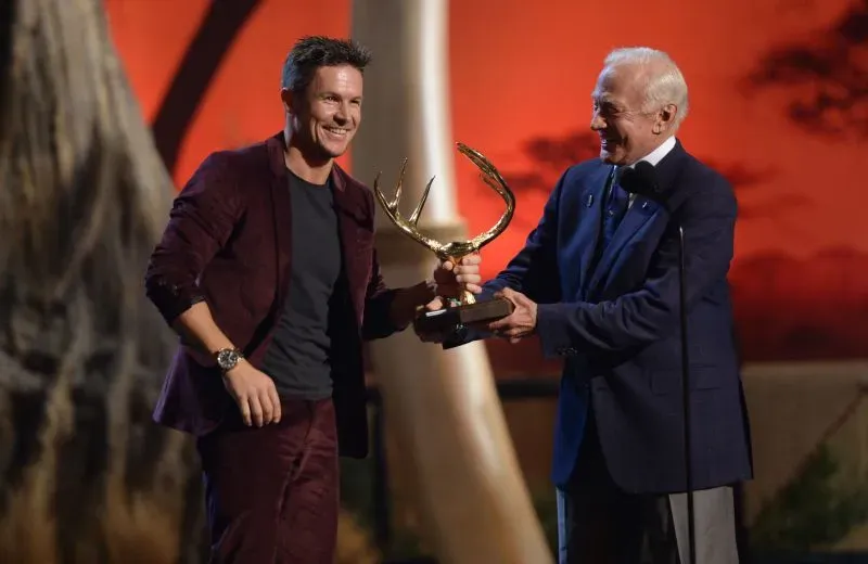 فيليكس بومغارتنر يتسلم جائزة من شخصية بارزة، مع تعبيرات الفخر والاعتزاز، خلال حدث تكريمي.