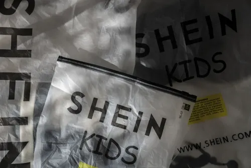 أكياس شحن تحمل شعار "شين كيدز"، تشير إلى زيادة التسوق عبر الإنترنت بعد إلغاء الإعفاءات الجمركية على الطرود منخفضة القيمة.