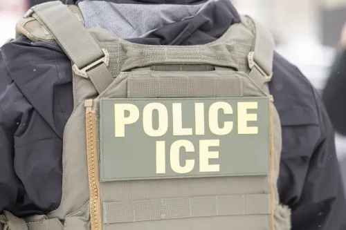 عميل فيدرالي يرتدي سترة واقية مكتوب عليها "شرطة ICE"، يظهر في مينيابوليس وسط أجواء من التوتر بسبب عمليات إنفاذ قوانين الهجرة.