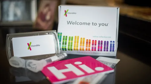 مجموعة من أدوات اختبار الحمض النووي من 23andMe، تشمل علبة جمع اللعاب وبطاقات تعريفية، تعكس المخاوف بشأن الخصوصية.