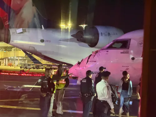 اصطدام طائرتين من طراز CRJ-900 في مطار لاغوارديا، مع وجود رجال أمن ومطار بجوار الطائرتين المتضررتين.
