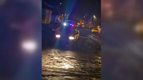 سيارة تغمرها مياه الفيضانات في شارع بمدينة غلوب بولاية أريزونا، مع وجود طواقم الإنقاذ في الخلفية أثناء جهود البحث.