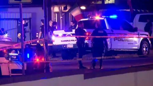 موقع الحادث في مطعم بأريزونا حيث تجمع رجال الشرطة حول سيارة شرطة بينما تتواجد أضواء الطوارئ.