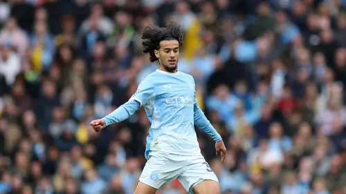 أيوب بوعدي لاعب وسط مانشستر سيتي يرتدي الزي الأزرق أثناء مباراة الدوري الإنجليزي، يعكس دوره الدفاعي والتمريرات الدقيقة.
