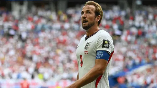 هاري كين قائد منتخب إنجلترا في مباراة كرة قدم، يرتدي شارة القيادة وقميص المنتخب الأبيض، وسط حضور جماهيري في الملعب.
