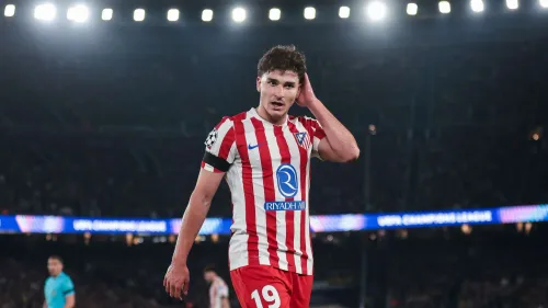 جوليان ألفاريز لاعب أتلتيكو مدريد يرتدي زي الفريق الأحمر والأبيض خلال مباراة في دوري أبطال أوروبا، مع تركيز على وجهه وتعابير الحيرة أو التفكير.