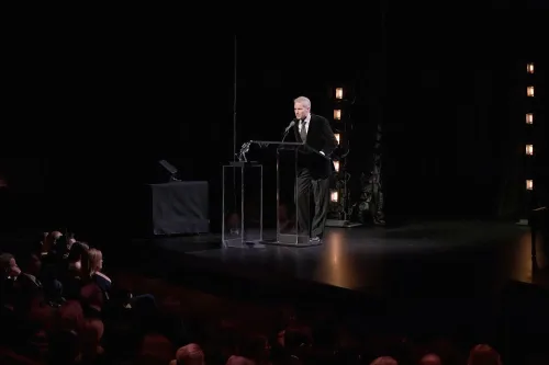 رجل يرتدي بدلة رسمية يتحدث إلى ميكروفون على خشبة المسرح أمام جمهور، في حدث يتعلق بالطاقة النووية والاندماج.