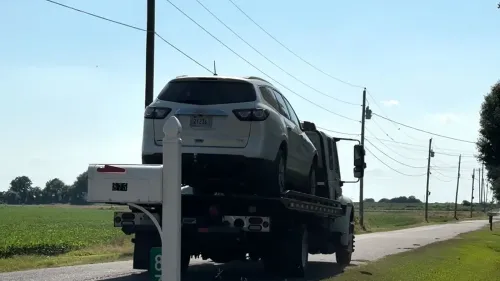 سيارة دفع رباعي بيضاء تُرفع على شاحنة سحب في منطقة ريفية بولاية تينيسي، حيث يجري التحقيق في حادثة مقتل عائلة.