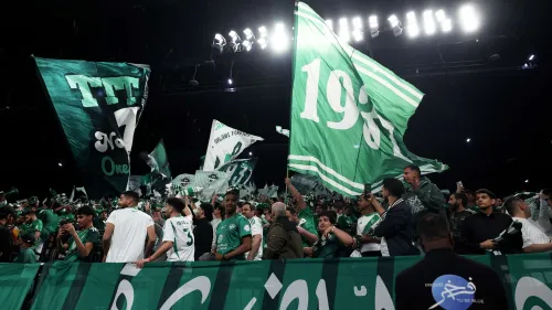 جماهير نادي الأهلي السعودي تلوح بأعلام خضراء في مدرجات ملعب خلال استعدادات دوري أبطال آسيا 2026-2027.