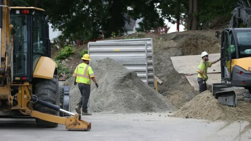 عمال يقومون بأعمال حفر في موقع بناء شبكة تدفئة حرارية أرضية في فرامنغهام، ماساتشوستس، لتحسين كفاءة الطاقة وتقليل التكاليف.