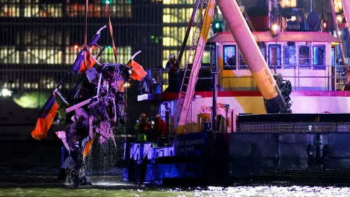 انتشال حطام طائرة هليكوبتر من نهر هدسون بعد تحطمها، مع وجود فرق الإنقاذ في موقع الحادث وسط أضواء المدينة.