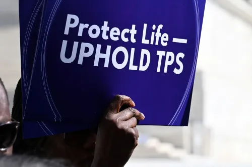 شخص يحمل لافتة تطالب بحماية الحياة ودعم وضع الحماية المؤقتة (TPS) للهايتيين، في سياق أزمة حقوق الإنسان في هايتي.