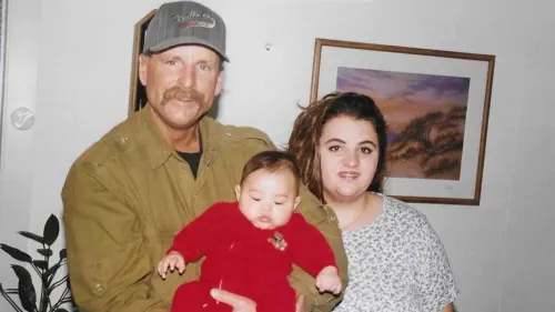 رجل مسن يحتضن طفلاً بينما تقف امرأة بجانبه، في لقطة عائلية تعكس اللحظات الدافئة قبل وفاة مايكل بورش في السجن.