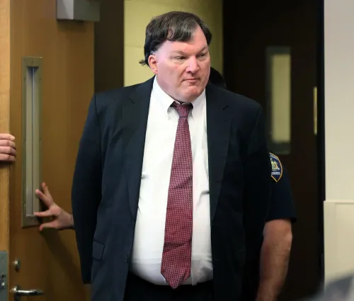 رجل يرتدي بدلة رسمية يدخل قاعة المحكمة، حيث يُتوقع أن تُناقش أدلة الحمض النووي في قضية قتل متهم بها.