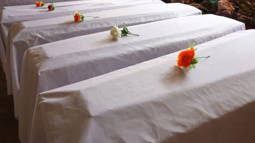 توابيت مغطاة بأقمشة بيضاء، مزينة بزهور ملونة، تعكس ذكرى ضحايا الإبادة الجماعية في رواندا عام 1994.