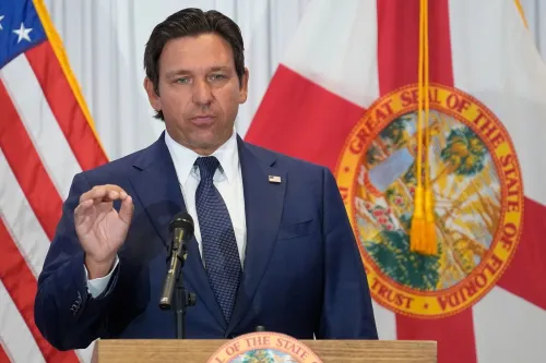 رون ديسانتيس، حاكم فلوريدا، يتحدث عن إلغاء الضرائب العقارية، مع العلم بوجود العلم الأمريكي وختم ولاية فلوريدا خلفه.