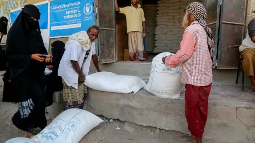 تظهر الصورة أفرادًا يتلقون مساعدات غذائية من برنامج الأغذية العالمي في اليمن، وسط أزمة إنسانية متفاقمة.