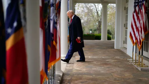 ترامب يسير في ممر البيت الأبيض بين أعلام الولايات، معبرًا عن تحدياته القضائية وسياساته المثيرة للجدل.