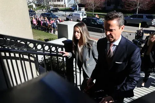 تظهر كارين ريد وهي تصعد السلالم إلى المحكمة برفقة محاميها، وسط حشد من أنصارها الذين يرتدون اللون الوردي دعمًا لقضيتها.