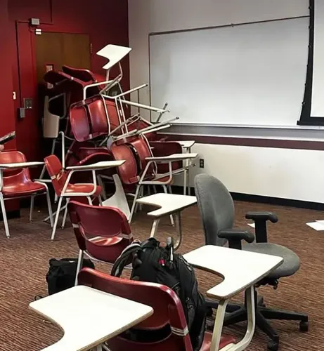 فصل دراسي فوضوي بعد إطلاق نار في جامعة ولاية فلوريدا، حيث تم تكديس الكراسي بشكل عشوائي، مع وجود حقائب وأثاث مبعثر.