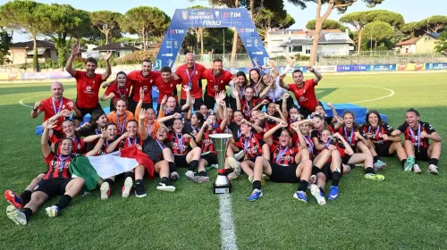 فريق أكاديمية AC Milan النسائية للشباب يحتفل بالفوز بكأس في ملعب كرة قدم ضمن مبادرة تطوير كرة القدم النسائية في إيطاليا.
