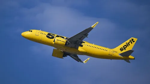 طائرة سبيريت الجوية الصفراء تحلق في السماء، مع التركيز على تصميمها المميز. تعكس الصورة سمعة الشركة كخيار اقتصادي آمن.