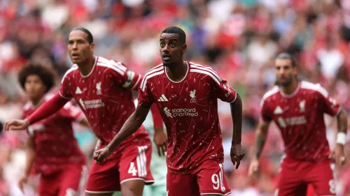 لاعبو نادي ليفربول يرتدون الزي الأحمر خلال مباراة في الدوري الإنجليزي الممتاز، مع تركيز على لاعب في المقدمة استعدادًا لتنفيذ ركلة حرة.