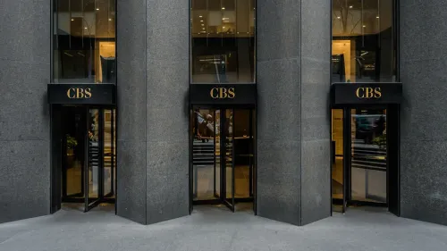مدخل مبنى شبكة سي بي إس نيوز، مع لافتات تحمل اسم الشبكة، يعكس التوترات المحيطة بتسوية باراماونت مع ترامب.