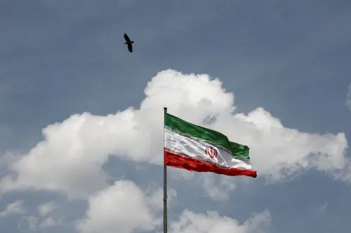علم إيران يرفرف في السماء مع غيوم، في سياق النزاع بين إيران والولايات المتحدة حول استهداف مراكز بيانات الذكاء الاصطناعي في الخليج.