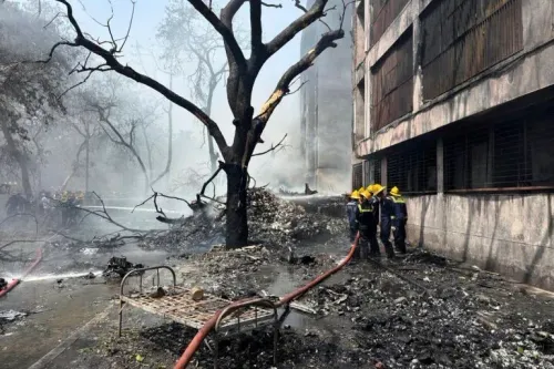 موقع تحطم طائرة الخطوط الجوية الهندية في ميغاني ناغار، مع رجال الإطفاء يعملون على إخماد النيران وسط الدخان والأنقاض.