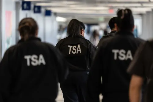 موظفو إدارة أمن النقل (TSA) يسيرون في مطار بالتيمور/واشنطن الدولي، حيث يشهد المسافرون طوابير طويلة بسبب نقص الموظفين.
