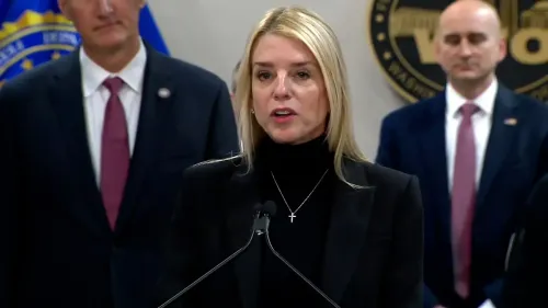 تتحدث المدعي العام بام بوندي في مؤتمر صحفي حول القبض على "زعيم رئيسي" لعصابة MS-13، مع وجود مسؤولين آخرين في الخلفية.