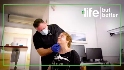 امرأة تتلقى تقييمًا طبيًا مع متخصص يرتدي كمامة، بينما يتم توصيل أجهزة مراقبة لها في بيئة طبية.