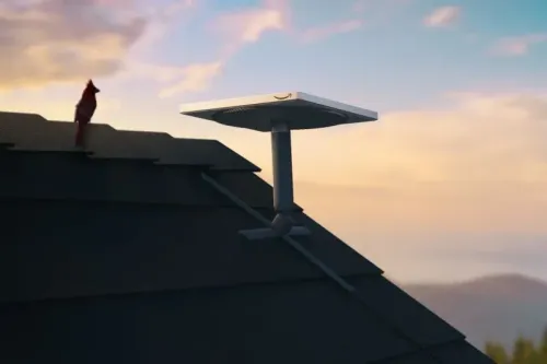 جهاز استقبال الإنترنت من مشروع كويبر التابع لأمازون مثبت على سطح منزل، مع سماء زاهية في الخلفية، يمثل خطوة نحو توفير الإنترنت العالمي.