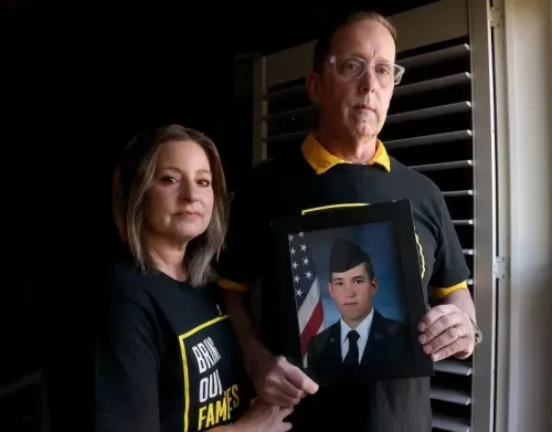 زوجان يحملان صورة لجوزيف سانت كلير، قدامى المحاربين المحتجزين في فنزويلا، يرتديان قمصانًا تحمل عبارة "أعيدوا عائلاتنا".