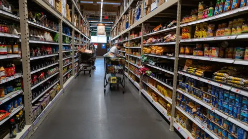 ممر داخل متجر يحتوي على أرفف مملوءة بالمنتجات الغذائية، مع تسوق شخص يحمل عربة تسوق. تعكس الصورة تراجع إنفاق المستهلكين وسط قلق اقتصادي.