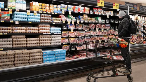 متسوق يقف أمام رفوف السوبرماركت، يتفحص البيض واللحوم، وسط مخاوف من ارتفاع التضخم وتأثيره على الأسعار.