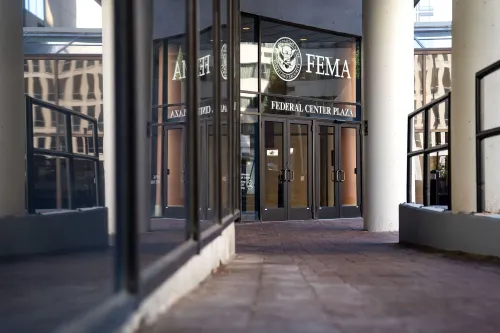 مدخل مركز الطوارئ الفيدرالي (FEMA) يظهر واجهة المبنى مع زجاج يعكس البيئة المحيطة، تعبيرًا عن الجدل السياسي حول استجابة الوكالة لإعصار هيلين.
