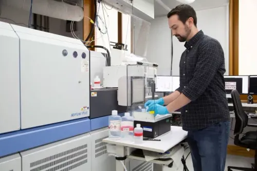 باحث يعمل في مختبر لتحليل عينات من أسنان الميجالودون، مع معدات علمية وأدوات تحضيرية، لدراسة عادات التغذية القديمة.