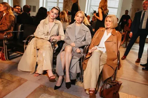 حضور ثلاث نساء في عرض أزياء رالف لورين، يرتدين معاطف أنيقة، يجلسن في صفوف أمامية في مكان عرض عصري، محاطات بجمهور متنوع.