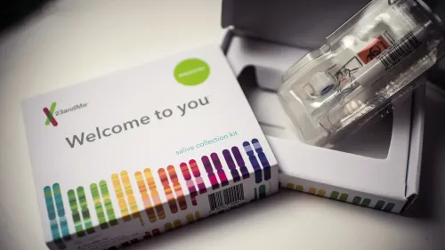 عبوة مجموعة جمع اللعاب من شركة 23andMe، مع شعار "مرحبًا بك"، تُظهر تفاصيل مهمة حول الاختبارات الجينية.