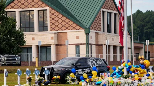 مشهد لسيارة شرطة في مدرسة أبالاتشي الثانوية، محاطة بزهور وبالونات، بعد اعتقال طالب بسبب حيازة سلاح.