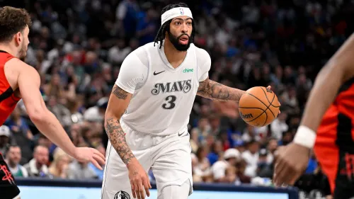 أنتوني ديفيس يحمل الكرة خلال مباراة مع دالاس مافريكس، مسجلاً 26 نقطة و16 كرة مرتدة، وسط تفاعل حماسي من الجمهور.