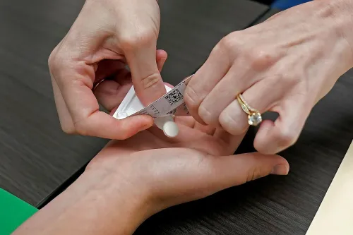 تظهر الصورة يدين تتبادلان حبوب الإجهاض الدوائي، مما يعكس التحديات القانونية المتعلقة بالإجهاض في الولايات المتحدة.