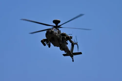 مروحية هجومية من طراز Boeing AH-64 Apache تحلق في السماء، في سياق تصاعد التوترات العسكرية بين الولايات المتحدة وإيران.