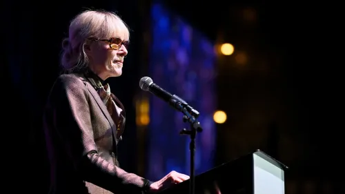 تظهر امرأة مسنّة ترتدي نظارات شمسية، تتحدث إلى ميكروفون خلال حدث عام، تعبيرًا عن موقفها بعد الحكم ضد ترامب في قضية الاعتداء والتشهير.