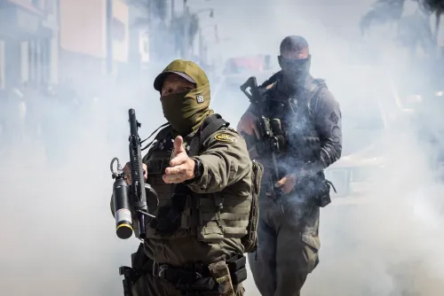 رجال أمن مسلحون يرتدون أقنعة في منطقة ملبدة بالدخان، خلال مواجهة مع متظاهرين في لوس أنجلوس، وسط توترات حول سياسات الهجرة.