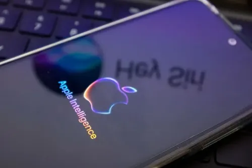 شعار "Apple Intelligence" يظهر على شاشة هاتف ذكي، مع انعكاس للوحة مفاتيح خلفية، مما يعكس تركيز آبل على الذكاء الاصطناعي.