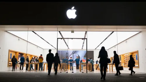 واجهة متجر آبل مضاءة، مع زبائن يتصفحون المنتجات داخل المتجر، وشعار آبل واضح في الأعلى، مما يعكس إطلاق iPhone 16e.