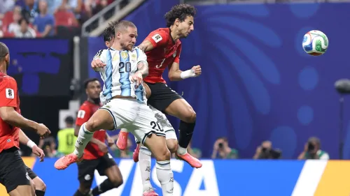 لاعبو منتخب الأرجنتين ومصر يتنافسون على كرة هوائية خلال مباراة كأس العالم، مع تركيز على لاعب أرجنتيني يرتدي القميص رقم 20.